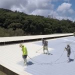Spray roofing application by Dura-Foam worker